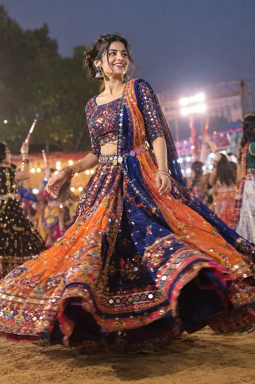Woman twirling in a mirror work lehenga at a Garba night
