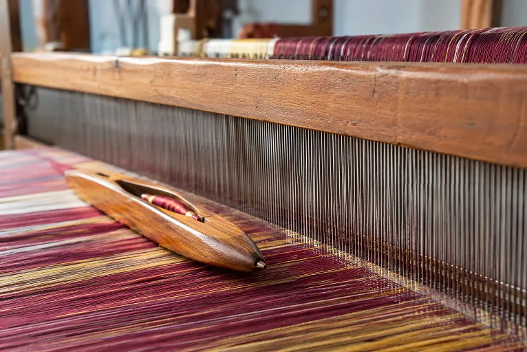 close-up of warp and weft threads interlacing on a saree loom