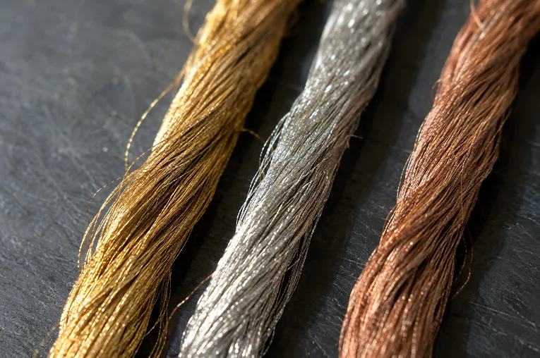 Close-up of gold and silver zari threads showing different zari grades