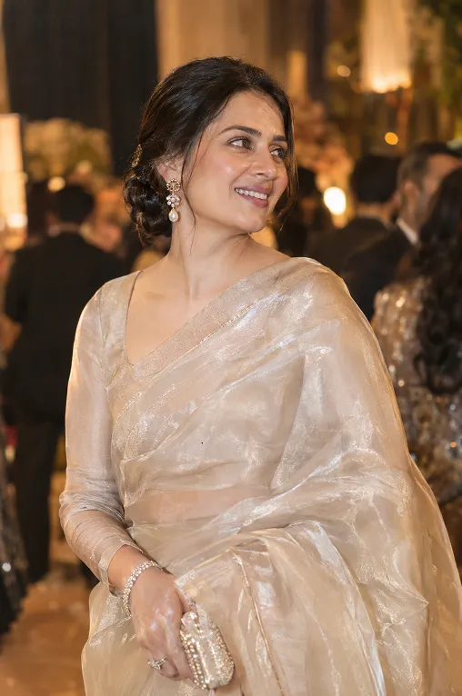 Woman in a champagne organza saree at a wedding reception
