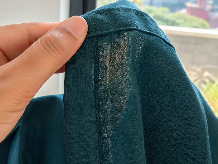 Close-up of cotton-linen kurta seam showing stitching quality and fabric detail in deep teal for working women kurtas