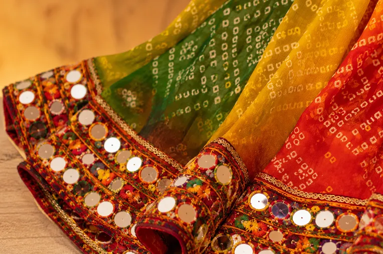 Close-up view of georgette chaniya choli fabric with mirror embroidery and bandhani details for Navratri outfit