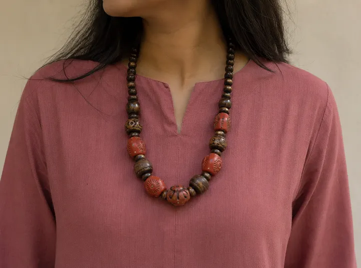 Chunky wooden and terracotta statement necklace paired with a dusty rose plain kurta neckline