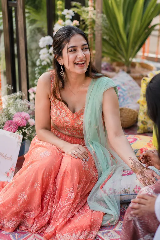 Lightweight coral lehenga with mint dupatta as a mehndi guest outfit idea