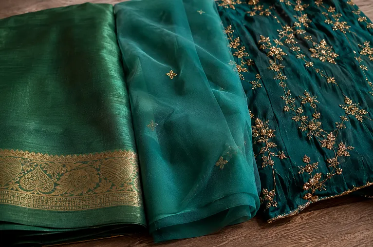 Coordinated emerald and gold fabric palette for a three generation Diwali family look