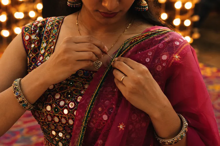 Close-up of cross-body dupatta pinning technique for garba dancing