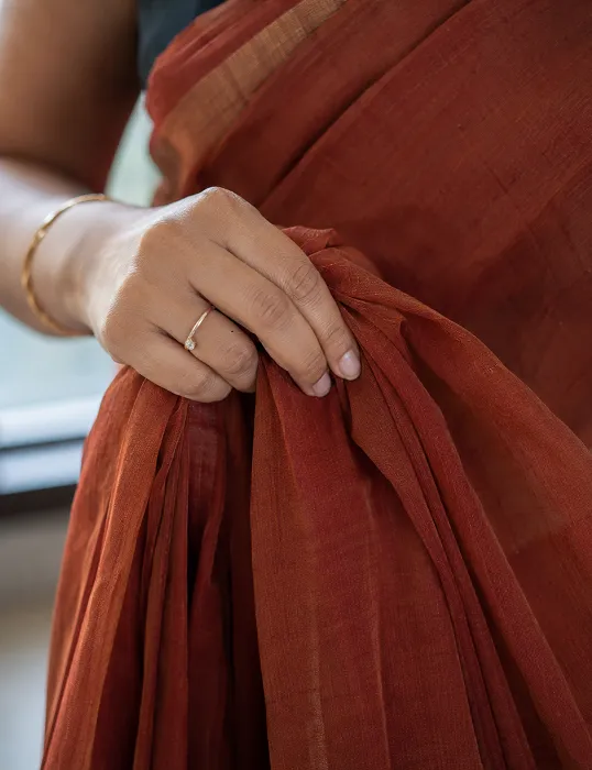 Close up of georgette saree fabric pleats held in hand showing texture