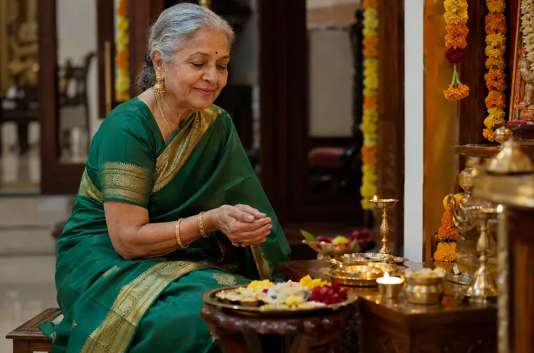 Grandmother in mid-weight silk saree seated comfortably during Diwali puja
