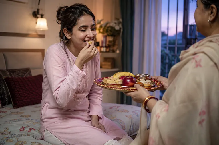 Woman eating sargi meal in a comfortable cotton kurta before sunrise on karva chauth