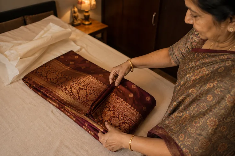hands folding a silk saree to prevent permanent creases
