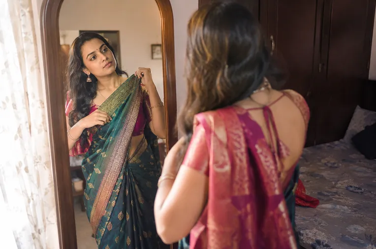woman practicing a saree drape at home before a destination wedding trip