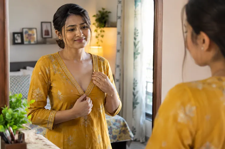 woman checking deep front neck of readymade kurti in mirror