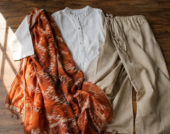 Flatlay of white kurti with rust dupatta and beige palazzo for mix and match pant colors for solid kurti