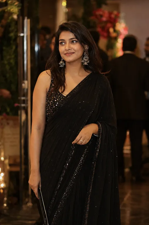Black saree with sequin blouse styled as a wedding reception guest outfit