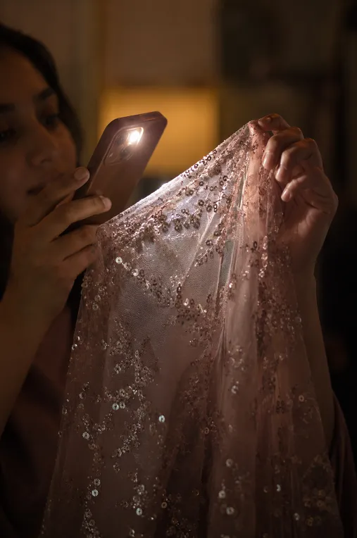 Checking embellished reception outfit fabric under light before buying